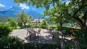 Eine Gruppe von Tischen und Stühlen vor dem Hintergrund der Berge in der Unterkunft Typically Swiss Hotel Altana in Scuol