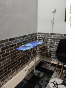 a ping pong table in front of a brick wall at Rumah Tamu Maryam in Temerloh
