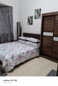 a bedroom with two beds and a dresser at Rumah Tamu Maryam in Temerloh