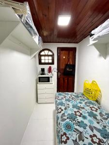 a small bedroom with a bed and a kitchen at Apartmento102 - Condomínio Brisa Mar in Cabo Frio +8 photos