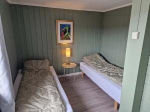 a small room with two beds and a table at Huset på øya in Vadsø