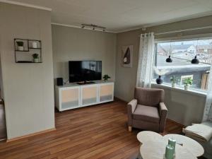a living room with a television and a chair and a table at Huset på øya in Vadsø