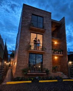 a couple standing on a balcony of a building at Luminoso departamento cerca de bodas y jardines! in Atlixco