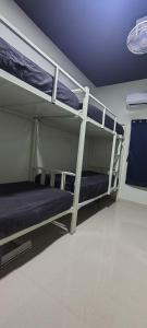 two bunk beds in a room with a blue ceiling at Thuyil Inn Koodal in Madurai