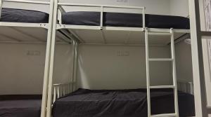 two bunk beds in a room with a bed at Thuyil Inn Koodal in Madurai