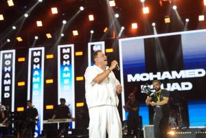 a man standing on a stage with a microphone at SEACODE Hotel in El Alamein