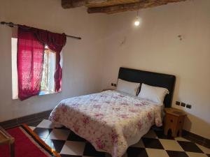 a bedroom with a bed and a checkered floor at Hostel amodou in Tinerhir