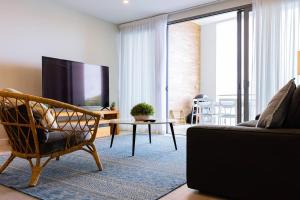 a living room with a couch and a tv at 403 - Suva City Views Oceanfront Large Balcony in Suva