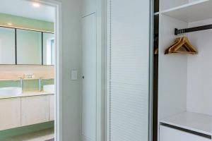a bathroom with white walls and a glass door at 403 - Suva City Views Oceanfront Large Balcony in Suva +26 photos