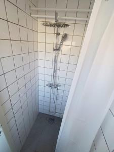 a shower in a white tiled bathroom at Double room 1 with Free Parking in Nørresundby +2 photos