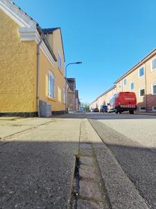 an empty street with a yellow building and a red truck at Double room 1 with Free Parking in Nørresundby