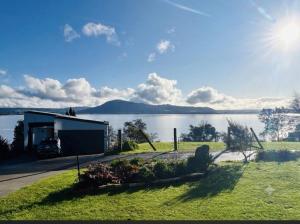 a house on the shore of a lake at Rotorua Lakes Cottage in Rotorua