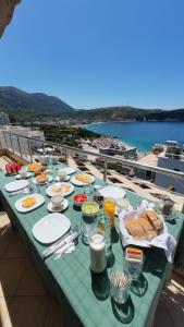 a table with food on it with a view of the water at Vila Kosteli in Himare