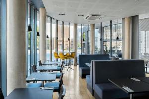 a restaurant with tables and chairs and windows at Four Points Flex by Sheraton Cardiff in Cardiff