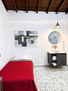 a bedroom with a red bed and a mirror at Hotel Ofix - Laureles in Medellín