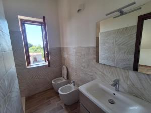 a bathroom with a sink and a toilet and a mirror at Il piccolo artista b&b in Naso
