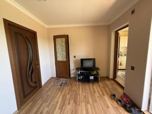 a living room with a door and a television and a floor at Relax in mountains in İsmayıllı
