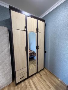 a large wooden cabinet with a mirror in a room at Relax in mountains in İsmayıllı