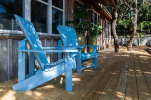 zwei blaue Stühle stehen auf der Veranda eines Hauses in der Unterkunft Artless Sprite in Santa Rosa Beach