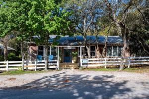 ein Holzhaus mit einem Zaun davor in der Unterkunft Artless Sprite in Santa Rosa Beach