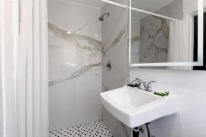 a white bathroom with a sink and a mirror at Encore Inn Inglewood in Inglewood +31 photos