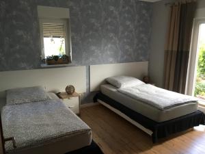 a bedroom with two beds and a mirror at La Vita in Ludwigslust