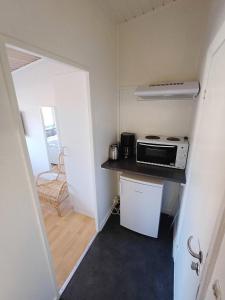 a small kitchen with a stove and a microwave at Double room 5 with Free Parking in Nørresundby +7 photos