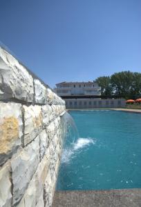 a swimming pool with a rock wall and water at Villa Lumi Mat in (( Mal i Kakariqit ))