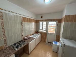 a small kitchen with a sink and a stove at Le bienvenu in Sousse