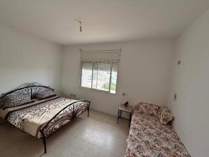 a bedroom with a bed and a chair in it at Le bienvenu in Sousse