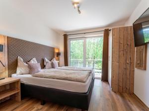 a bedroom with a bed and a large window at Werfenblick in Werfenweng