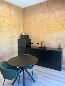 a kitchen with a table and two chairs and a sink at Pirongia Views Studio in Pirongia