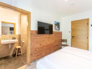 a bedroom with a bed and a sink and a tv at Chalet Sylvia in Krimml