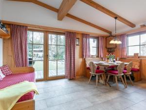 ein Esszimmer mit Tisch, Stühlen und Fenstern in der Unterkunft Schneeberghütte in Thiersee