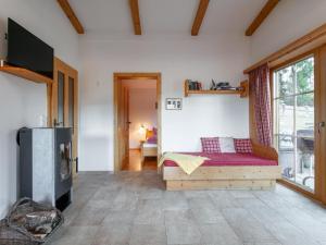 ein Wohnzimmer mit einem Bett und einem großen Fenster in der Unterkunft Schneeberghütte in Thiersee