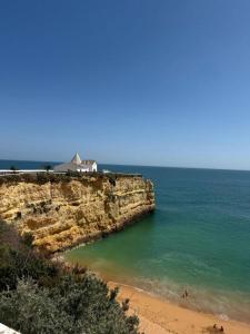 a house on top of a cliff next to the ocean at Villa Do Mar in Porches