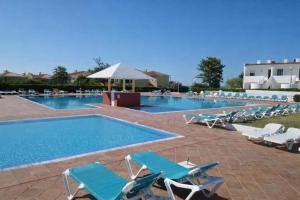 a large swimming pool with lounge chairs and a swimming pool at Villa Do Mar in Porches