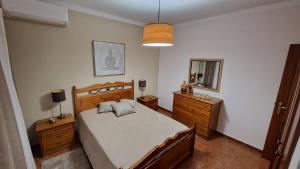 a bedroom with a bed and a dresser and a mirror at Villa Do Mar in Porches +18 photos