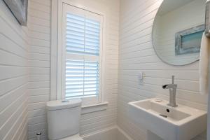a white bathroom with a toilet and a sink at Magnolia Honeymoon Cottage in Santa Rosa Beach +48 photos