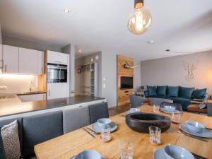 a kitchen and a living room with a table and chairs at Hirnreit in Leogang