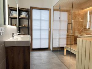 a bathroom with a sink and a glass shower at Haus Bente in Donnersbachwald +24 photos