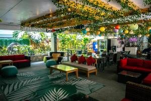 a restaurant with red couches and tables and plants at Waikiki Beachside Hostel in Honolulu
