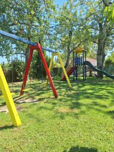 ein Spielplatz mit bunten Spielgeräten im Rasen in der Unterkunft Chroma Studios in Oreoi