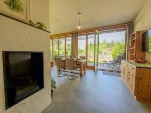 a living room with a fireplace and a table with chairs at See Chalet 50 in Lake Pressegg