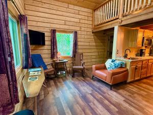a living room of a log cabin with a couch and a chair at Riverfront, Authentic, Luxury Log Cabin-Gray Wolf in Wasilla