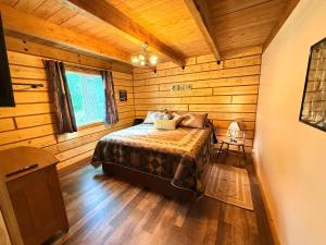 a bedroom with a bed in a wooden cabin at Riverfront, Authentic, Luxury Log Cabin-Gray Wolf in Wasilla