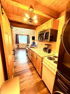 a kitchen with wooden cabinets and a stove top oven at Riverfront, Authentic, Luxury Log Cabin-Gray Wolf in Wasilla
