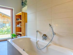 a bathroom with a bath tub with a shower at Oselitzen 56 in Lake Pressegg +48 photos
