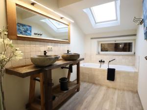 two sinks in a bathroom with a mirror and a tub at Léoras Cocoon in Membre +33 photos