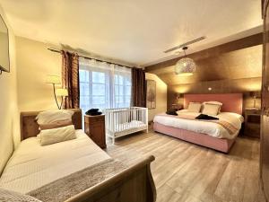 a bedroom with two beds and a crib at Léoras Cocoon in Membre